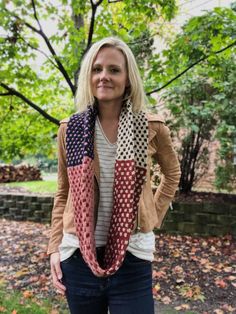 a woman standing in front of a tree with her hands on her hips wearing a scarf