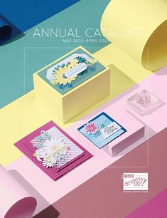 the annual catalog is displayed on a colorful surface with flowers and cards in it, as well as an empty box