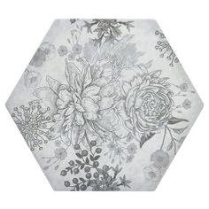 a white and gray floral pattern on a hexagonal tile