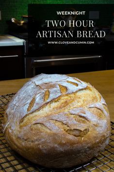 a loaf of artisan bread sitting on top of a cooling rack in front of an oven