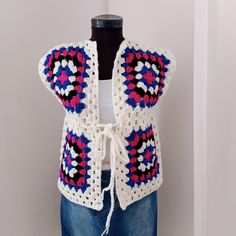 a crocheted vest is displayed on a mannequin