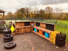 an outdoor kitchen made out of pallets and wooden crates with wheels on the ground