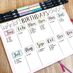 a birthday calendar with markers and pencils next to it on a wooden table top