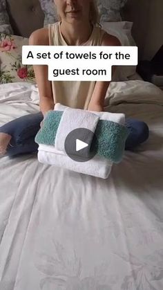 a woman is sitting on her bed with towels in front of her and the caption reads, a set of towels for the guest room