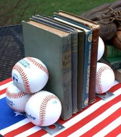 baseballs and books are sitting on a table with an american flag cloth in the background