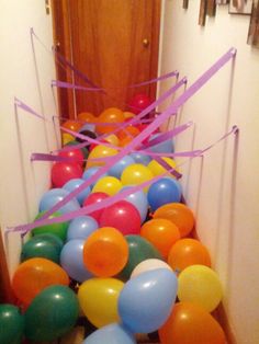 balloons and streamers are lined up on the floor in front of an entrance way