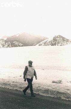 a man walking across a snow covered field