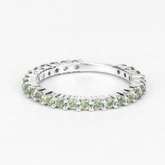 Peridot Ring, Natural Peridot Rounds Full Eternity Band Ring in .925 Sterling Silver, August Birthstone, Engagement Ring, Promise RingFlaunt yourself with this Peridot .925 Sterling Silver Eternity Band ring. The natural gemstones have a combined weight of 0.94 carats and are set in .925 sterling silver with rhodium plating. The green hue of this ring adds a pop of color to any look!  The understated design and vibrant stones makes this ring perfect for every occasion.Product Details: .925 Sterl Green Gemstone Eternity Band For Promise, Green Cubic Zirconia Round Band Rings, Green Cubic Zirconia Half Eternity Jewelry, Green Halo Ring With Round Band, White Gold Peridot Rings With Prong Setting, Stackable Peridot Rings For Anniversary, Stackable Peridot Anniversary Jewelry, Stackable Peridot Jewelry For Anniversary, Silver Peridot Ring With Round Cut