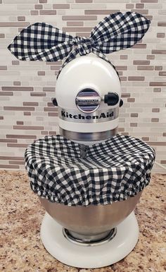 a kitchen aid mixer with a black and white checkered bow on it's head