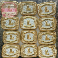 some gold and white decorated cookies with the letter l on it's front side