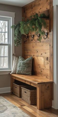 a wooden bench sitting next to a window filled with plants and hanging hooks on the wall