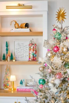 a white christmas tree with gold and green ornaments