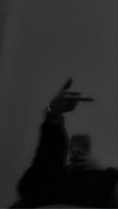 a blurry image of a person holding a remote control in their hand and pointing at something on the wall