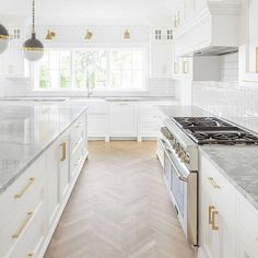 a kitchen with white cabinets and gold trimmings on the counter tops is pictured in this image