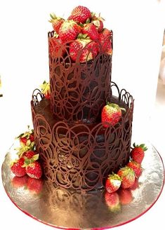 a three layer chocolate cake with strawberries on top