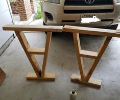 two wooden benches sitting in front of a car