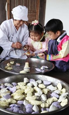 two children and an adult looking at some food