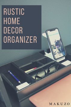 a desk with a cell phone, pen and glasses on it next to an organizer