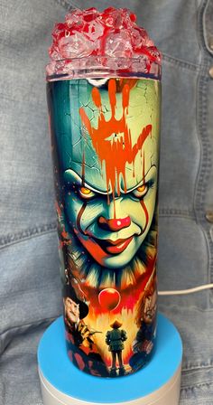 an image of a clown painted on the side of a cup with ice in it