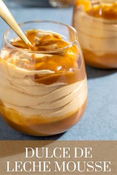 two glasses filled with dessert sitting on top of a table