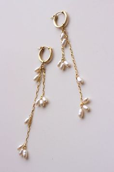 Completely handcrafted in our New York studio, the Falling Petals Mini Hoop Earrings feature genuine freshwater pearls. Lightweight and easy to wear. Wear them two ways - slide the dangle off to wear just the simple hoop earring. Ear wires: hoop Materials: 14k Gold Filled or Sterling Silver Measures approx. 3 3/4" (longest strand) in length Handmade in New York Arrives in a keepsake clutch and box Good Dangle Earrings, Gold Earrings With Pearls, Simple Earrings Design, Easy To Make Earrings, Easy Wire Earrings, Handmade Drop Earrings, Handmade Earrings Ideas, Pearl And Gold Earrings, Handmade Pearl Earrings