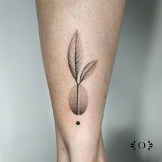 a woman's leg with a small leaf tattoo on it