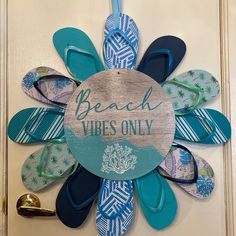 a sign that says beach vibes only with flip flops hanging on the front door