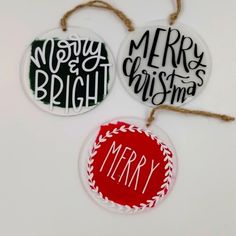 three christmas ornament hanging from twine on white background with merry message in red and green