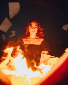 a woman standing in front of a fire