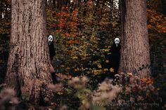 two ghostly people standing in the middle of a forest with trees and leaves around them