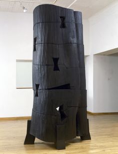 a large piece of wood with holes cut out of it's sides in an art gallery