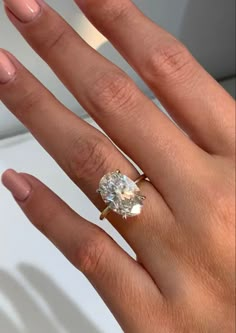 a woman's hand with a diamond ring on it