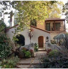 a house that is surrounded by plants and trees