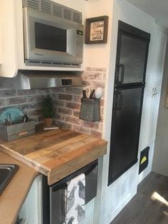 a kitchen area with a microwave, sink and refrigerator