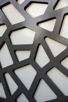 a close up view of an abstract metal surface with white and black geometric designs on it