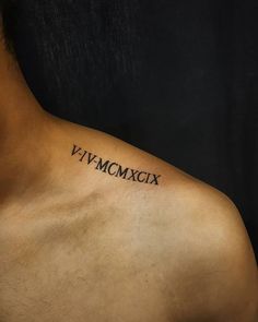 a man's chest with roman numerals tattooed on his left side shoulder