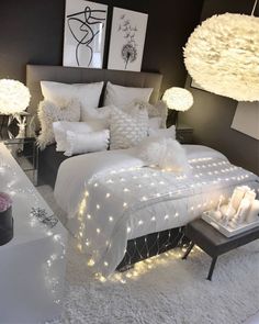 an instagram photo of a bedroom with white bedding and lights on the walls