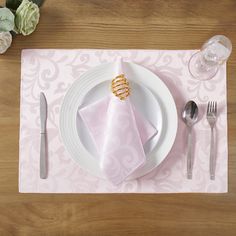 a place setting with pink napkins and silverware