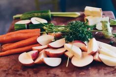 apples, carrots and celery on a cutting board