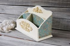 a white and blue wooden desk organizer with tissue paper on the floor next to it