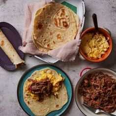 three plates filled with food next to two bowls of eggs and tortilla bread