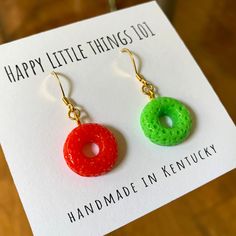 These red and green Cheerios earrings will match any outfit. It's a great holiday gift for your besties, kiddos, or someone you love. We use quality 18K gold plated stainless. All the earrings are nickel free & safe for sensitive skin. Have fun!! These adorable earrings will make everyone smile during the holiday season❤️ Thank you for the taking the time out to look at our earrings. Please visit our shop for more original design: https://www.etsy.com/shop/HappyLittleThings101 Follow us for upda Fun Orange Earrings For A Gift, Fun Orange Earrings For Gift, Novelty Red Earrings For Gift, Fun Green Fruit Design Earrings, Red Christmas Novelty Jewelry, Silly Holidays, Christmas Accessories, Earrings Christmas, Earring Holder