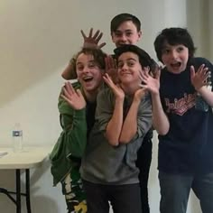 group of kids posing for the camera with their hands in the air