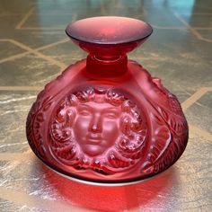 a red glass vase sitting on top of a table