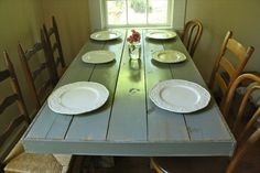 the table is set with plates and place settings for four people to sit down at