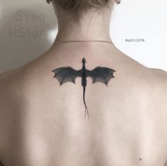 the back of a woman's neck with a dragon tattoo on it