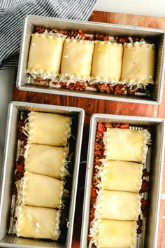 three pans filled with food sitting on top of a wooden table