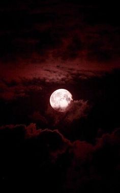 the full moon is shining brightly in the night sky with clouds and dark red hues