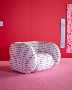 a white chair sitting on top of a pink floor next to a wall with red walls