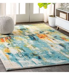 a blue and yellow area rug with an abstract design on the floor in front of a window